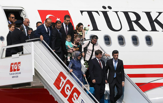 Turkeyâs Prime Minister Ahmet Davutoglu (C) and his wife Sare Davutoglu (L), welcome freed Turkey's Consul in Mosul Ozturk Yilmaz (R) and dozens of other freed Turkish nationals hostages held by Islamist militants in northern Iraq for more than three months, on September 20, 2014 at the Esenboga Airport in Ankara. (AFP Photo)
