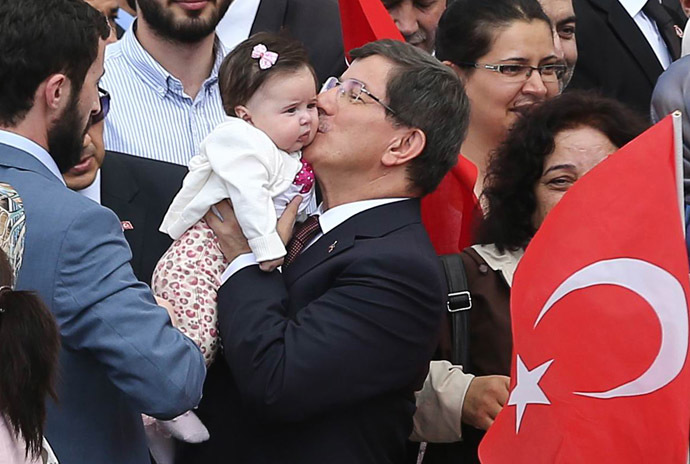 Turkeyâs Prime minister Ahmet Davutoglu (C) kisses the daughter of a hostage as he welcomes on September 20, 2014 in Ankara dozens of freed Turkish nationals hostages held by Islamist militants in northern Iraq for more than three months. (AFP Photo)