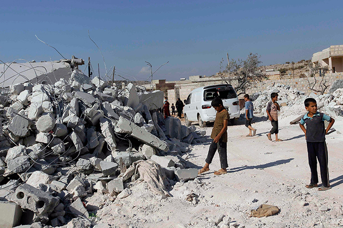 Residents inspect damaged buildings in what activists say was a U.S. strike, in Kfredrian, Idlib province September 23, 2014 (Reuters / Abdalghne Karoof)