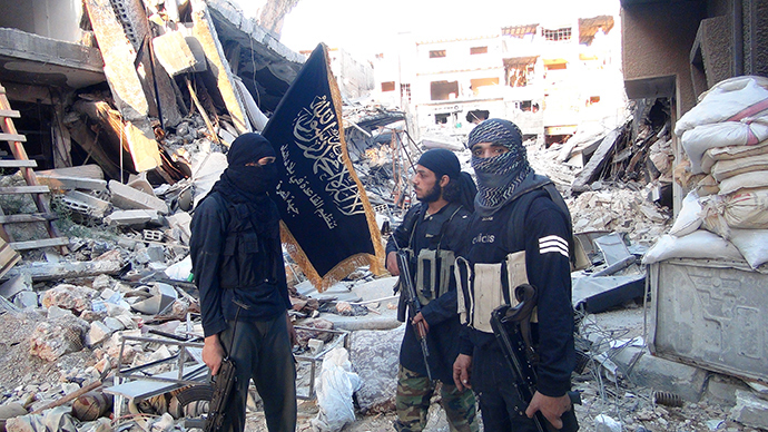 Fighters from the al-Qaida group in the Levant, Al-Nusra Front, stand among destroyed buildings near the front line with Syrian government solders in Yarmuk Palestinian refugee camp, south of Damascus on September 22, 2014 (AFP Photo / HO)
