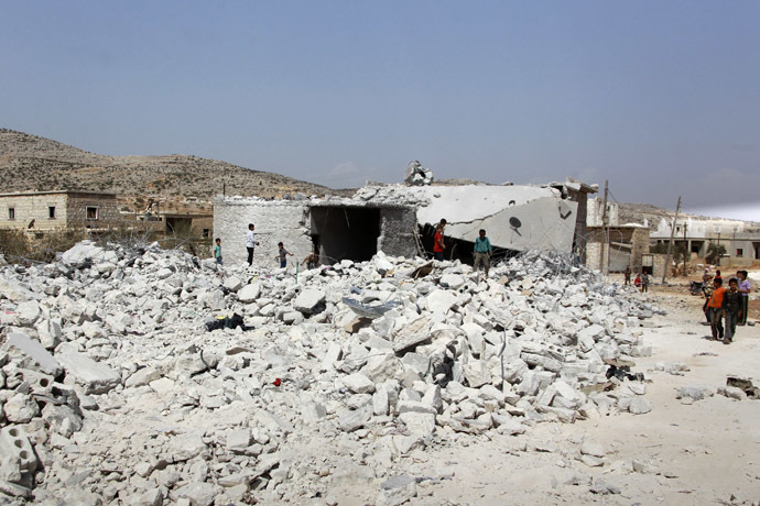 Residents look at buildings which were damaged in what activists say was one of Tuesday's U.S. air strikes in Kfredrian, Idlib province September 24, 2014. (Reuters/Ammar Abdullah)