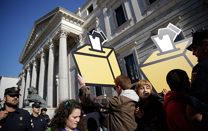 Pro-independence supporters hold cut-outs of ballot box next to Spanish riot police during a protest in front of the Spanish parliament in Madrid September 30, 2014 (Reuters / Andrea Comas)