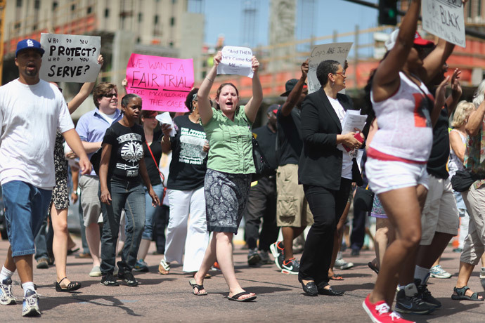 Demonstrators walk through the street near the Buzz Westfall Justice Center where a grand jury will begin looking at the circumstances surrounding the fatal police shooting of an unarmed teenager Michael Brown on August 21, 2014 in Clayton, Missouri. (Joe Raedle / Getty Images / AFP)
