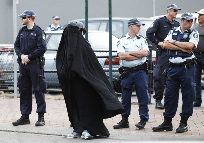 Police officers stand on guard next to a woman wearing a burqa near the venue where controversial Dutch member of parliament Geert Wilders will speak in the Sydney suburb of Liverpool February 22, 2013. (Reuters/Daniel Munoz)