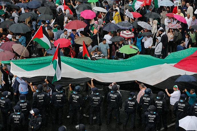 German police watches demonstrators during a Muslim protest against the Israeli assault on the Gaza Strip in Berlin, July 25, 2014. The protest took part on the annual "al-Quds Day" (Jerusalem Day) rally against the Israeli occupation of the city of Jerusalem (Reuters / Fabrizio Bensch)