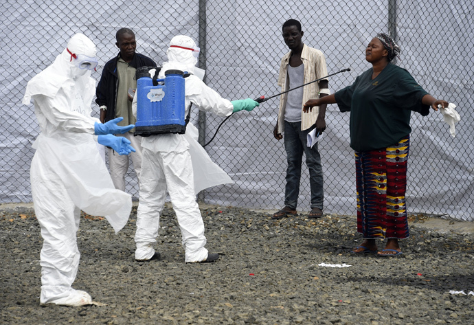 Medical personnel at the Ebola treatment centre at Island hospital in Monrovia (Liberia) disinfect people who had brought patients suspected of having the Ebola virus (AFP Photo / Pascal Guyot)