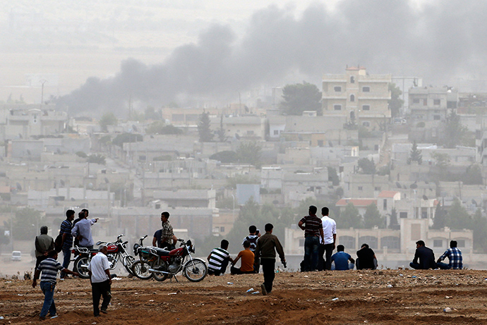 Turkish Kurds watch over the Syrian town of Kobani as they stand on top of a hill near Mursitpinar border crossing in the southeastern Turkish town of Suruc in Sanliurfa province October 11, 2014 (Reuters / Umit Bektas)