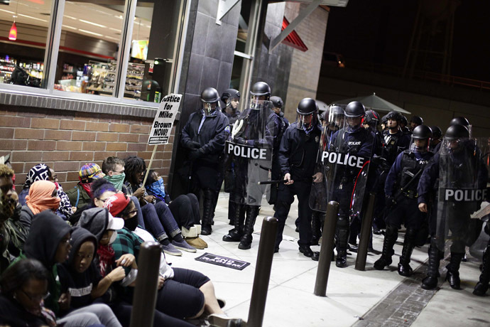 Police officers in riot gear hold a line as demonstrators protest the shooting death of Michael Brown and 18-year-old Vonderrit Myers Jr. at a QuikTrip convince store and gas station October, 12 2014 in St. Louis, Missouri. (AFP Photo/Joshua Lott)