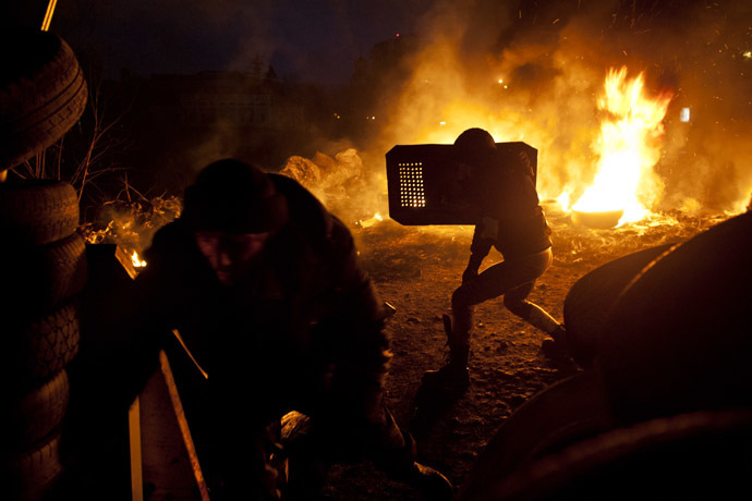 Anti-government protesters run in front of burning barricades on February 20, 2014, at the Independent square, known as Maidan, in Kiev on February 20, 2014 in Kiev. (AFP Photo/Piero Quaranta)