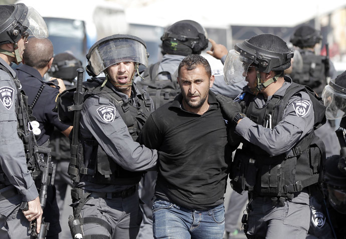 Palestinians shout slogans holding placards as they gather near the entrance of al-Aqsa mosque compound to protest after authorities restricted access to the esplanade on October 15, 2014 outside Jerusalem's Old City. (AFP Photo/Ahmad Gharabli)