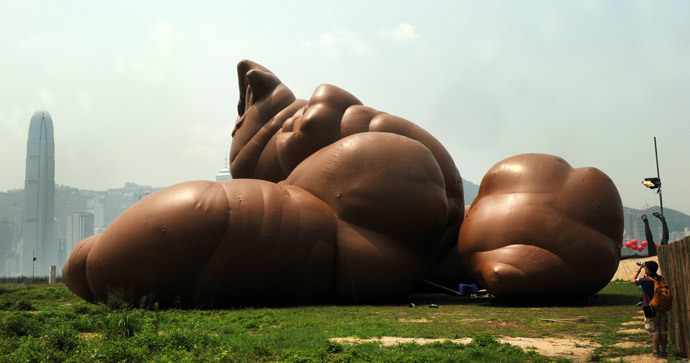 A journalist takes photos of a sculpture by US artist Paul McCarthy titled "Complex Pile" during a press preview of the Mobile M+: Inflation! exhibition in Hong Kong on April 24, 2013. (AFP Photo / Laurent Fievet)