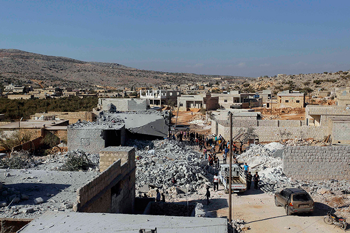 Residents inspect damaged buildings in what activists say was a U.S. strike, in Kfredrian, Idlib province September 23, 2014 (Reuters / Abdalghne Karoof)