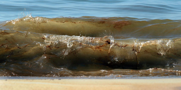 Waves carry in blobs of oil as it washes ashore from the Deepwater Horizon oil spill in the Gulf of Mexico on June 26, 2010 in Orange Beach, Alabama. (Joe Raedle / Getty Images / AFP)