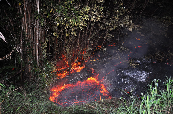 This October 28, 2014 image provided by the US Geological Survey(USGS) shows the lava flow eminating from the Kīlauea volcano in Hawaii moving through thick vegetation near the Pahoa cemetery. (AFP Photo)
