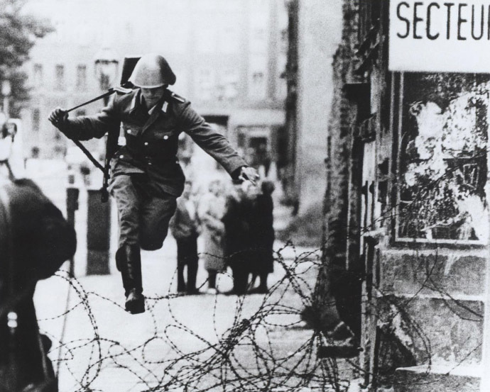 Conrad Schumann escaping across the barbed wire (Image from flickr.com/The Central Intelligence Agency)