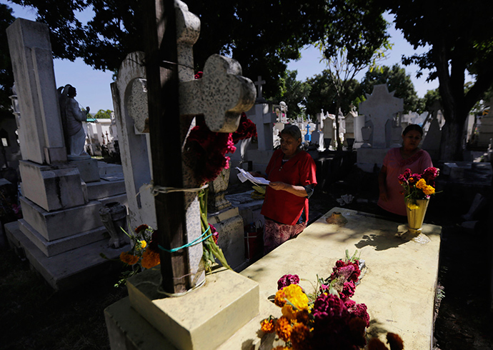 Women pray at the grave of a relative at the municipal cemetery during the Day of the Dead, in Iguala in the southwestern state of Guerrero (Reuters / Henry Romero)
