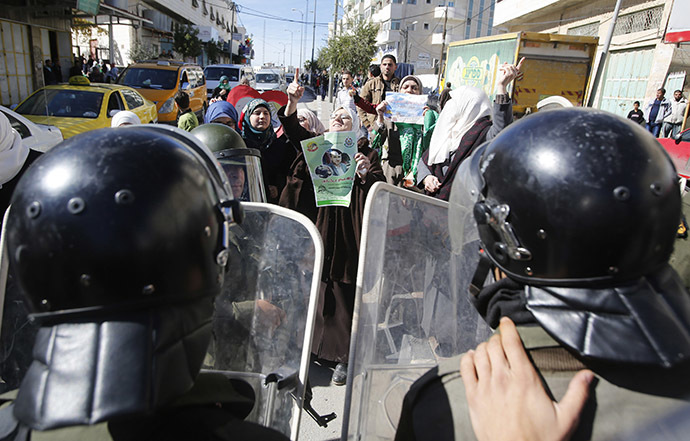 Members of Palestinian security forces take position as Palestinian women take part in an anti-Israel protest against what organizers say are recent visits by Jewish activists to al-Aqsa mosque, in the West Bank city of Hebron November 7, 2014. (Reuters/Mussa Qawasma )