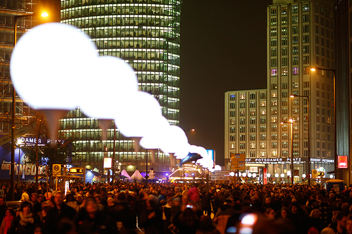 People walk under the lit balloons placed along the former Berlin Wall at Potsdamer Platz as part of the installation 'Lichtgrenze' (Border of Light) in Berlin, November 9, 2014. (Reuters / Hannibal Hanschke)