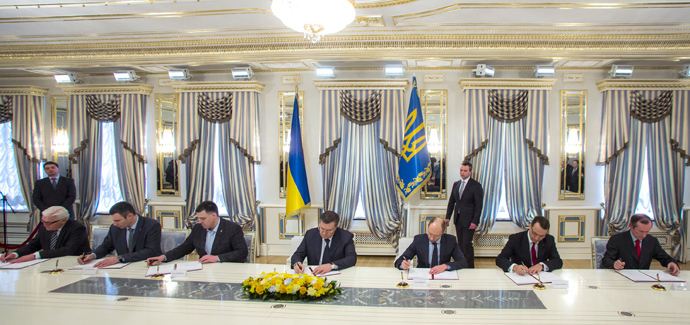 Ukraine's President Viktor Yanukovich (C) signs an EU-mediated peace deal with opposition leaders in Kiev February 21, 2014 (Reuters / Pool)