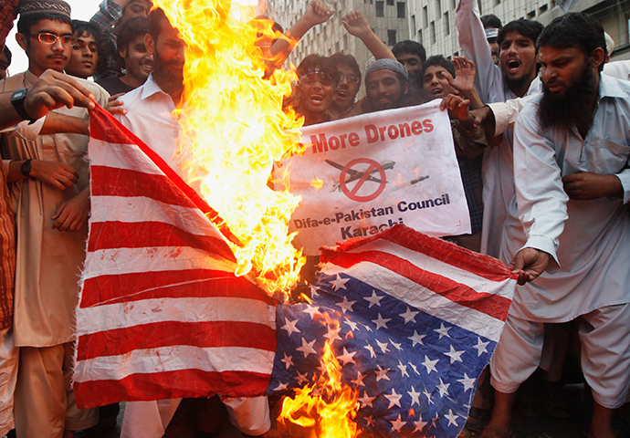 Supporters of the Difa-e-Pakistan Council, an Islamic organization, burn a U.S. flag as they shout slogans during a protest against U.S. drone attacks in the Pakistani tribal region, in Karachi November 8, 2013 (Reuters / Athar Hussain)