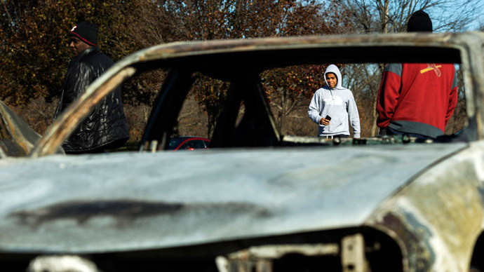 People walk towards a car lot where several cars had been burned and damaged following a night of rioting in Ferguson, Missouri November 25, 2014.(Reuters / Lucas Jackson)
