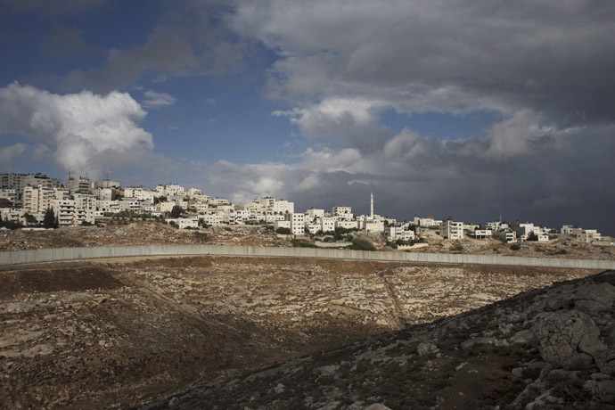 A section of the controversial Israeli barrier cuts beneath the West Bank refugee camp of Shuafat, October 31, 2014. (Reuters/Finbarr O'Reilly)