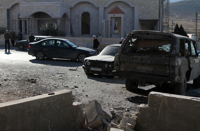Lebanese men stand at a site hit by rockets fired from the neighbouring war-torn Syria in Ras Baalbeck in Lebanon's Bekaa valley. (AFP Photo / Str)