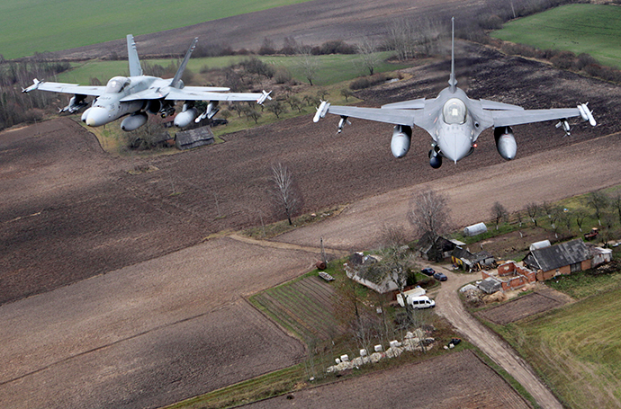 Portuguese Air Force fighter F-16 (R) and Canadian Air Force fighter CF-18 Hornet patrol over Baltics air space, from the Zokniai air base near Siauliai. Lithuania. (Reuters / Ints Kalnins)