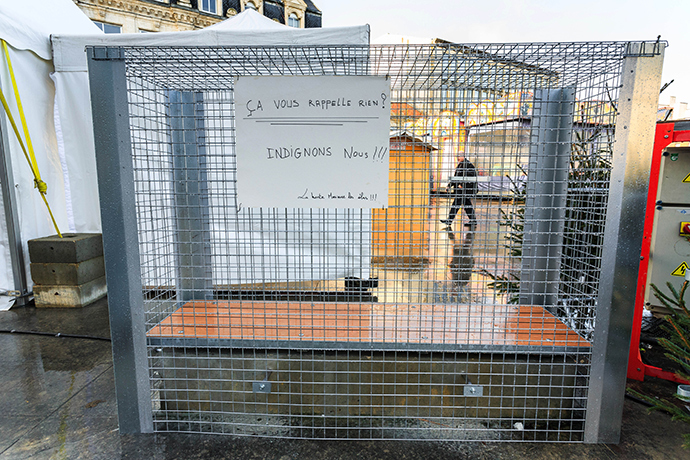 A sign reads "Does this ring you any bells ? Let's get angy" as wire grid has been placed around a public bench to prevent homeless from drinking alcohol and sleeping on it, on December 25, 2014 in Angouleme, southwestern France (AFP Photo / Pierre Duffour)