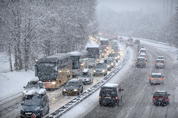 Snow fall as vehicles move bumper-to-bumper along the motorway near Albertville, on December 27, 2014 as they make their way into the Tarentaise valley in the heart of the French Alps, home to many of the famous French ski resorts. (AFP Photo / Jean-Pierre Clatot)