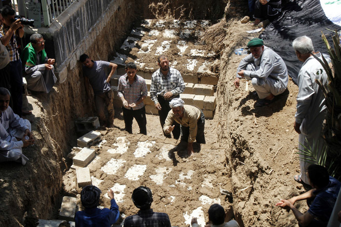 Mourners bury the bodies of victims, who were killed in Tuz Khurmato, during a funeral in Kirkuk, June 23, 2014. (Reuters/Ako Rasheed)