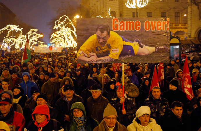 A woman holds a placard showing Hungarian Prime Minister Viktor Orban as a soccer player during an anti-government protest called by civil groups in Budapest January 2, 2015 (Reuters / Laszlo Balogh)