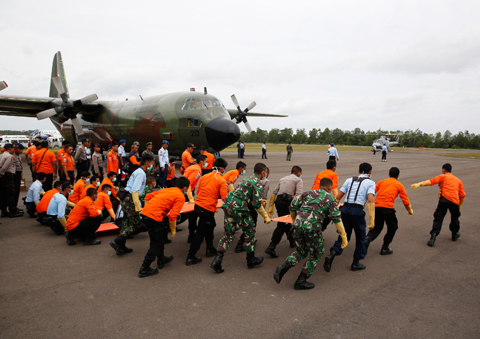 Indonesian Search and Rescue and security forces run to greet helicopters transporting the bodies of AirAsia QZ8501 passengers recovered from the sea at the airport in Pangkalan Bun, Central Kalimantan January 3, 2015 (Reuters / Darren Whiteside)