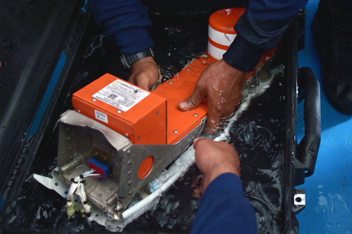 Indonesian divers onboard the Indonesian navy vessel KRI Banda Aceh handle the FDR (Flight Data Recorder) of the AirAsia flight QZ8501 after it was retrieved from the Java Sea on January 12, 2015. (AFP Photo/Adek Berry)