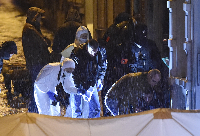 Policemen and forensic police work under the rain in a marked out perimeter in Colline street in Verviers, eastern Belgium, on January 15, 2015, after two men were reportedly killed during an anti-terrorist operation. (AFP Photo / John Thys)