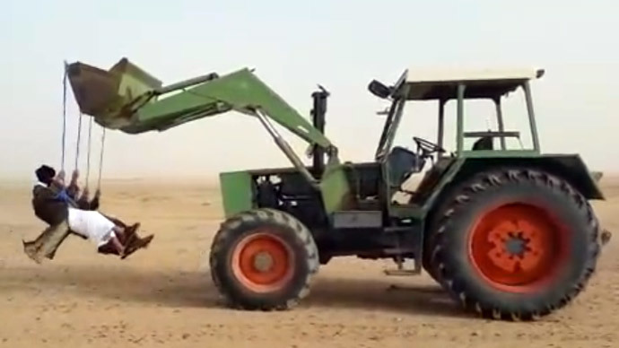 Having fun in Saudi desert: Daredevils swinging from reversing tractor (VIDEO)