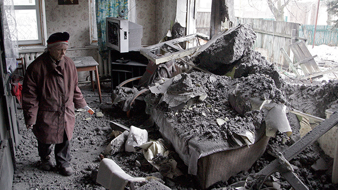A woman surveys damage done to a house, which according to locals was recently damaged by shelling, in the suburbs of Donetsk January 30, 2015 (Reuters / Alexander Ermochenko)