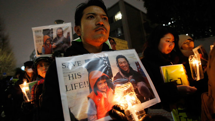 People holding placards take part in a vigil in front of Prime Minister Shinzo Abe's official residence in Tokyo, January 30, 2015.(Reuters / Toru Hanai)