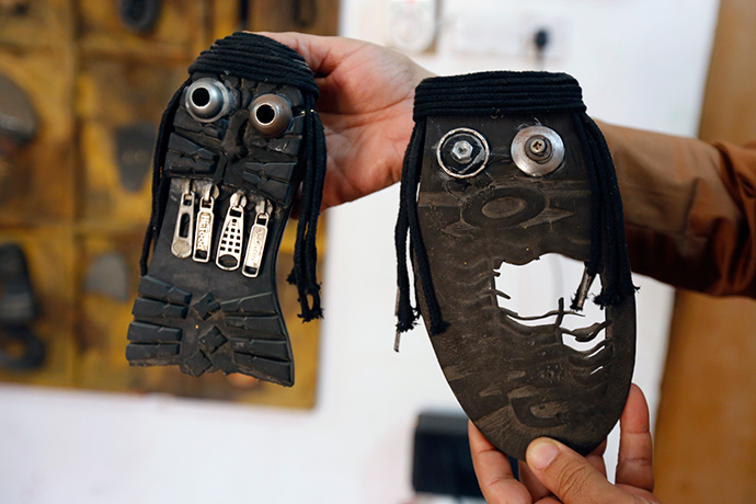 Iraqi artist Akeel Khreef shows some of his art pieces depicting jihadists on the soles of worn-out shoes on January 13, 2015 in Baghdad (AFP Photo / Sabah Arar)