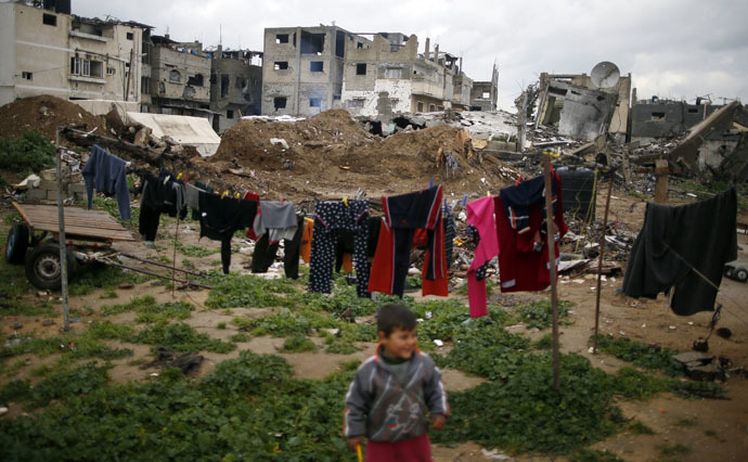 A Palestinian boy plays near the ruins of his family house that witnesses said was destroyed by Israeli shelling during a 50-day war last summer, east of Gaza City February 18, 2015. (Reuters/Mohammed Salem)