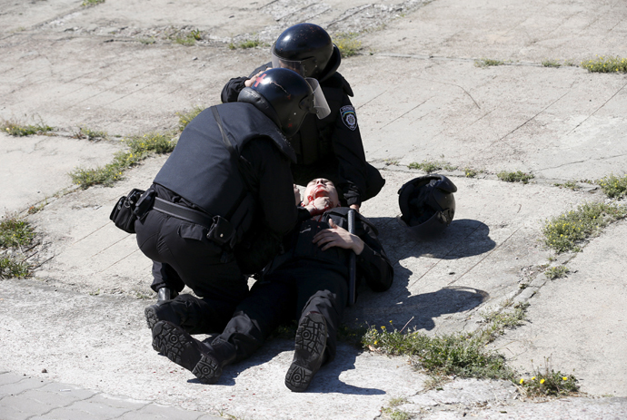 Interior Ministry members apply first aid to their colleague who was injured in clashes with anti-gay protesters during the so-called Equality March, organized by a lesbian, gay, bisexual and transgender (LGBT) community, in Kiev, Ukraine, June 6, 2015. (Reuters / Stringer)