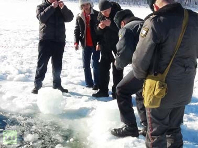 Police officers, environmentalists and EMERCOM experts at the site of a meteorite hit in the Chelyabinsk Region. Small 0.5-1 cm pieces of black matter resembling rock were found around the ice hole caused by the meteorite. Photo courtesy of the press service of the Interior Ministry′s Main Directorate for the Chelyabinsk Region.(RIA Novosti)