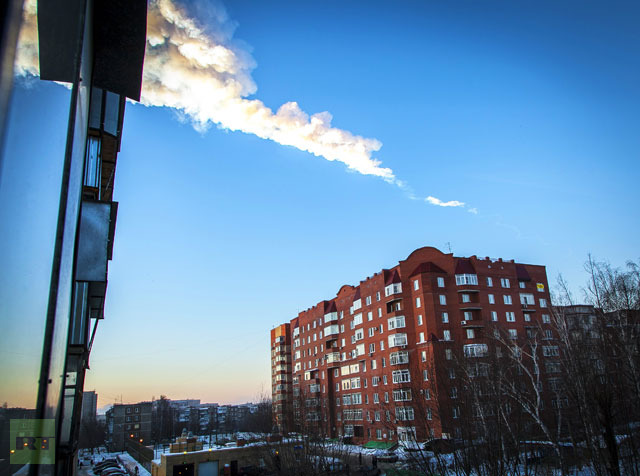 The trail of a falling object is seen above a residential apartment block in the Urals city of Chelyabinsk, on February 15, 2013.(AFP Photo / Oleg Kargopolov)