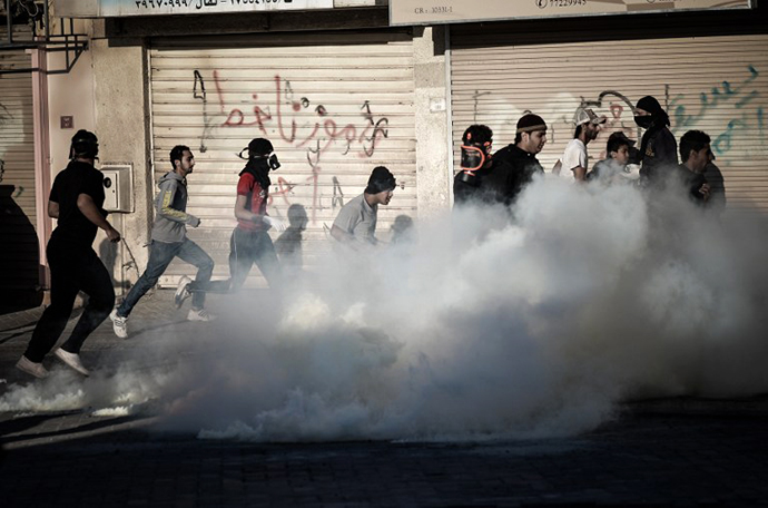 Anti-regime Bahraini protestors run for cover from tear gas and bird shots fired by riot police during clashes on February 22, 2013. (AFP Photo / MohammedAl-Shaikh)