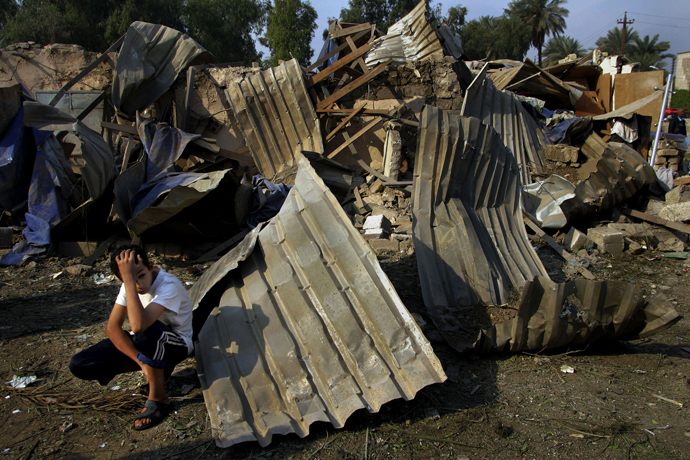 An Iraqi boy shows his dejection in front of his destroyed house at the site where two suicide bombers detonated explosives-laden cars near Al Hamra hotel, that houses foreign journalists, and an interior ministry complex at Al Jadriyah district, in central Baghdad, Iraq, 18 November 2005 (AFP Photo / Mauricio Lima)
