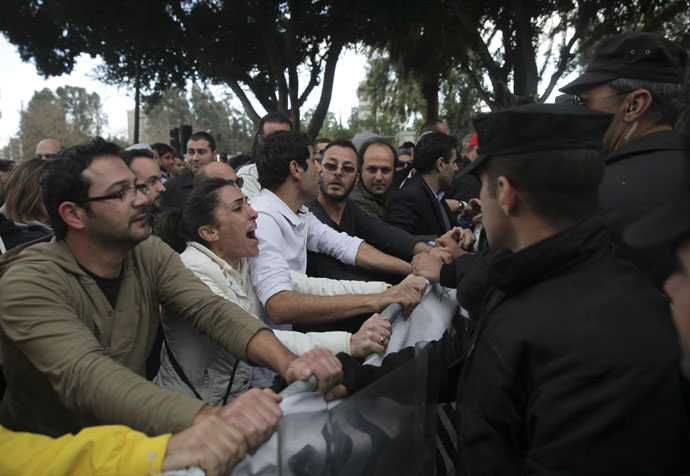 Employees of Cyprus' Laiki (Popular) Bank protest outside the parliament building in the capital Nicosia on March 22, 2013.(AFP Photo / Yiannis Kourtoglou)