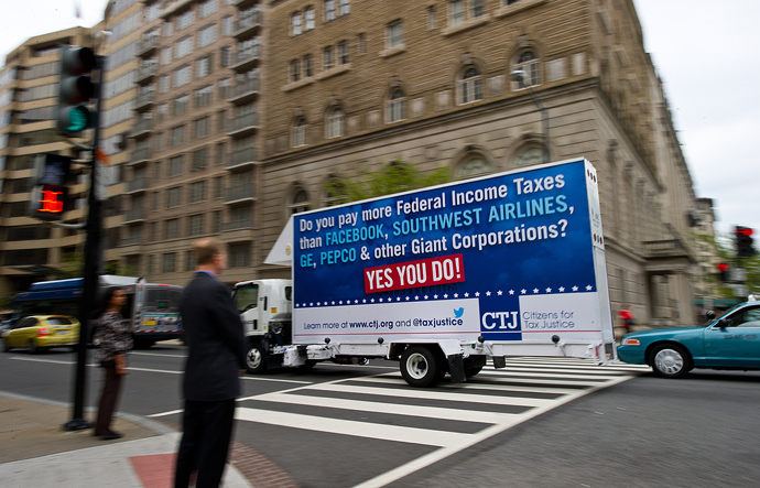 A rolling billboard sponsored by Citizens for Tax Justice (CTJ), reading: "Do you pay more Federal Income Taxes than Facebook, Southwest Airlines, GE, Pepco and other Giant Corporations? Yes You Do!" A CTJ report, "Ten Reasons We Need Corporate Tax Reform," crosses an intersection in Washington, DC (AFP Photo / Karen Bleier)