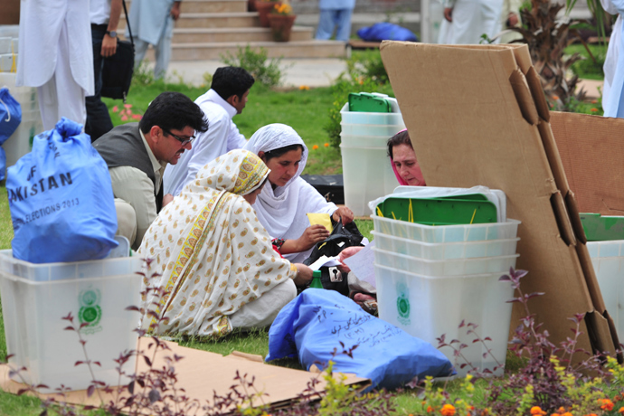 Pakistani election presiding officers and their staff sit with election materials at the distribution point in Rawalpindi on May 10, 2013 (AFP Photo / Farooq Naeem)