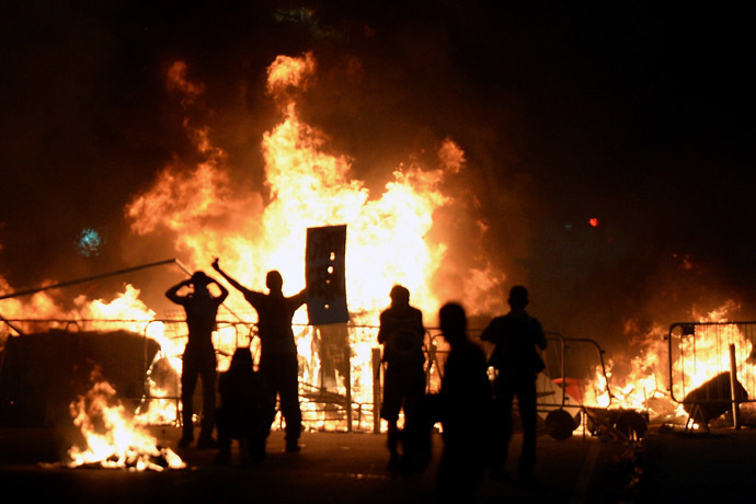 Demonstrators stand next to a fire during a protest part of what is now called the 'Tropical Spring' against corruption and price hikes, on June 20, 2013, in Rio de Janeiro. (AFP Photo)