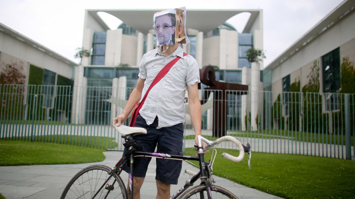 An activists of the organization Campact demonstrates in front of the German Chancellery in support of fugitive US intelligence leaker Edward Snowden (featuring his face on the paper bag), on July 4, 2013 in Berlin, Germany. (AFP Photo)